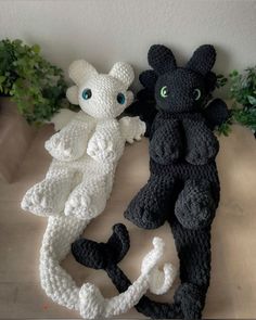 two crocheted stuffed animals sitting next to each other on top of a table