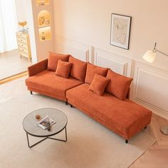 a living room with an orange couch and coffee table