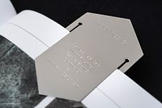 a close up of an open book on a black background with white paper and silver foil