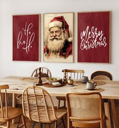 two christmas paintings hanging on the wall above a dining room table with chairs and place settings