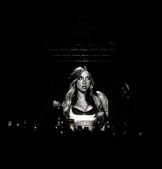 a woman standing in front of a crowd at a concert