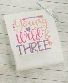 a white t - shirt with the words young, wild and three written on it