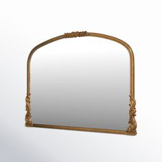 an ornate gold framed mirror hanging on the wall