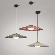 three pendant lights hanging from the ceiling in various colors and sizes, with one light turned on