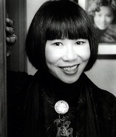 a black and white photo of a woman with short hair smiling at the camera,