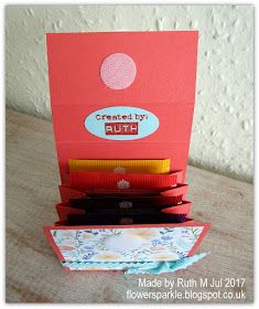 an open red card box on top of a wooden table next to a pile of folded cards