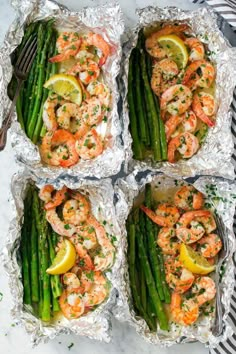 four foil packets filled with shrimp and asparagus on top of a marble counter