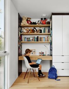 a young boy sitting at a desk using a laptop computer