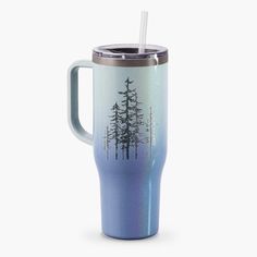 a cup with a straw in it and trees on the side, sitting against a white background