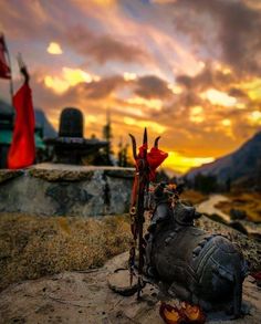 a statue sitting on top of a rock next to a red and white flag in the background