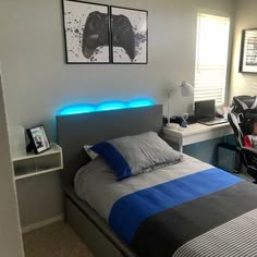 a bed room with a neatly made bed next to a computer desk and two framed pictures on the wall