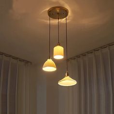 three lights hanging from the ceiling in a room