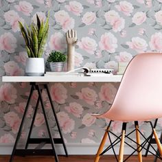 a pink chair sitting in front of a desk with a potted plant on it