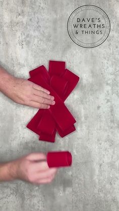 a hand reaching for some red objects on the floor