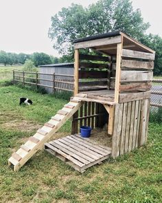 a dog house made out of pallets with a ramp to the top and bottom