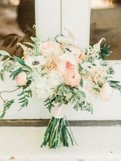 a bouquet of flowers sitting on top of a window sill in front of a white door