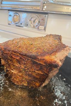 a piece of meat sitting on top of a frying pan next to an oven