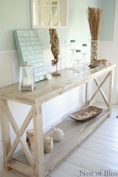 a wooden table sitting in the middle of a room with vases and candles on it