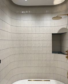 a white bath tub sitting next to a wall mounted shower faucet in a bathroom