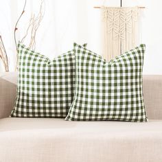 two green and white checkered pillows on a couch