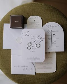 the wedding stationery is laid out on top of an envelope and some other items