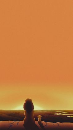 a person sitting on a bed looking out at the ocean with an orange sky in the background