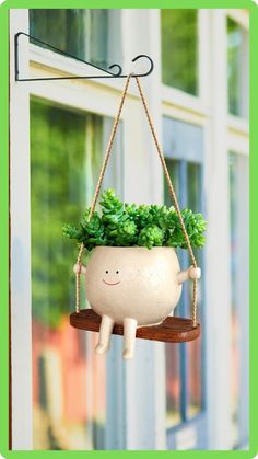 a white planter hanging from a window sill