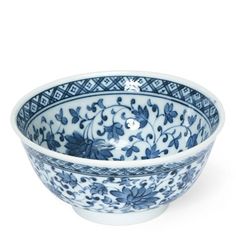 a blue and white bowl with floral designs on the rim, sitting in front of a white background