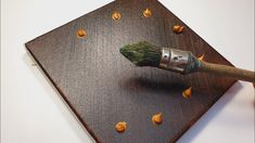 a paintbrush on top of a piece of wood