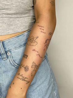 a woman's arm with tattoos on it and writing on the side of her arm