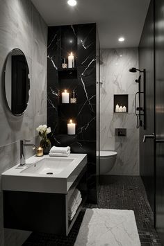 a black and white bathroom with candles on the wall