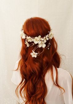 the back of a woman's head wearing a white flowered hair vine with leaves