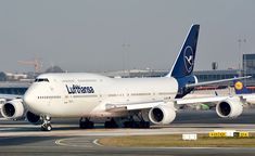 an airplane that is sitting on the tarmac with other planes in the back ground