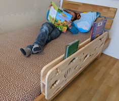 a young boy laying on top of a bed reading a book