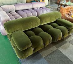 three different colored couches sitting next to each other on a checkerboard floor