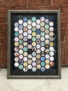 a frame with many different types of magnets on the side of a brick wall