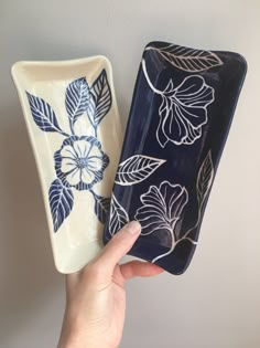 two blue and white flowered dishes are shown in the foreground, one being held up by a person's hand