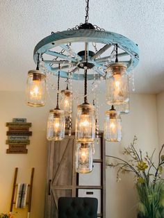 a chandelier with mason jars hanging from it's center and lights in the middle