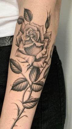 a black and white rose tattoo on the arm