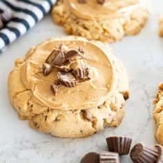 cookies with peanut butter frosting and chocolate chips on a marble counter top next to striped napkins