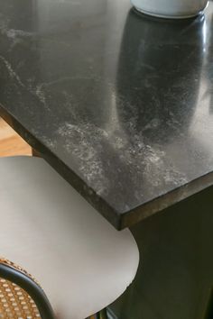 a black counter top sitting next to a chair