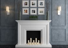 a white fireplace in a room with pictures on the wall and candles lit next to it