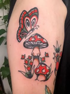 a mushroom tattoo with butterflies on it