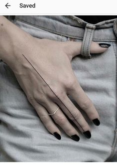 a woman's hand with black nail polish on it and a small line in the middle