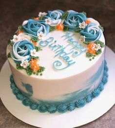 a blue and white birthday cake with flowers on it