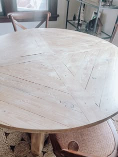 a round wooden table sitting on top of a rug