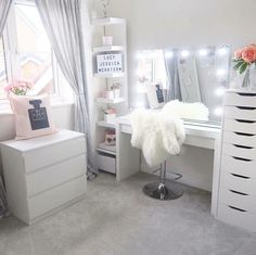 a bedroom with white furniture and lights on the windowsill