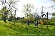 several people are playing soccer in the grass on a sunny day with net and trees