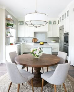 a dining room table with chairs around it and a chandelier hanging from the ceiling