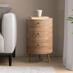 a wooden cabinet with two drawers next to a white couch